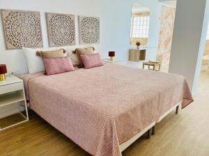 a bedroom with a large bed with pink pillows at Luxury Sunset Ocean View in Arguineguín