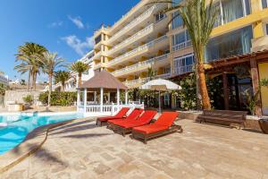 a swimming pool with lounge chairs and a hotel at Luxury Sunset Ocean View in Arguineguín