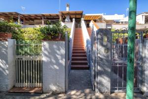 una escalera que conduce a una casa con una puerta en Casa a 2 passi dalla Spiaggia, en Platamona