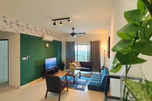 a living room with a green wall and a couch at Aldridge Residence Cosy Apt @EMIRA Residence in Shah Alam