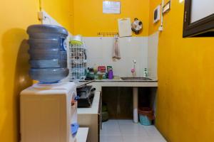 a small kitchen with a sink and a refrigerator at KoolKost Syariah at Jelutung Jambi in Jambi