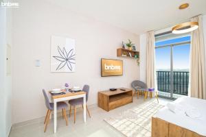 uma sala de estar com uma mesa e cadeiras e uma cama em bnbmehomes - Great Value Modern Studio with Luxury Amenities - 1508 no Dubai