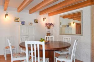 a dining room with a wooden table and white chairs at Villa Marina in Pollença
