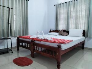 a bedroom with a bed with a red blanket on it at joseys homestay in Cochin