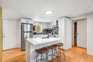 una cucina con ampia isola bianca con sgabelli da bar di Moonlight Cottage at Lake Alice a Fall City Altre 32 foto