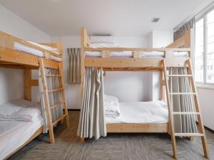 a room with two bunk beds in a hostel at Super conveniently located The GUEST HOUSE HAKODATE BAY in Hakodate