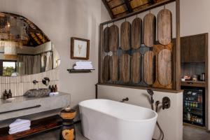 ein Badezimmer mit einer weißen Badewanne und einem Waschbecken in der Unterkunft Simbavati Waterside in Klaserie Private Nature Reserve