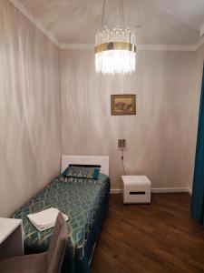 1 dormitorio con cama y lámpara de araña en Nicole en Úzhgorod