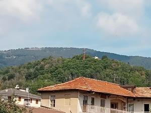 a house in front of a hill with a tower at Ca Dei City in Coazze