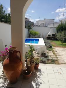 een patio met potplanten en een zwembad bij Alle Volte Salento in Trepuzzi
