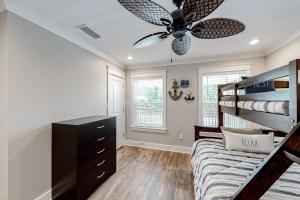 a bedroom with a bunk bed and a ceiling fan at Beach Cottage South in Dauphin Island