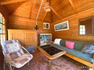 Sala de estar con sofá y silla en una cabaña en VH CostaBlanca - GOLONDRINA, en Calpe