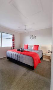a bedroom with a large bed with red pillows at Paihia Apartments in Paihia