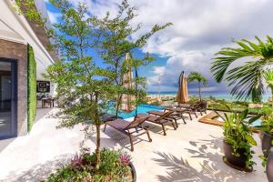 a patio with tables and chairs and a swimming pool at Actual Chic 502 at A Perfect Place in Playa del Carmen