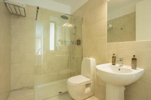 e bagno con servizi igienici, lavandino e doccia. di Madeinterranea Apartments a Málaga