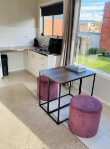 a kitchen with a table and a purple stool at Yours and Theirs Pet Friendly Accommodation in Myrtleford