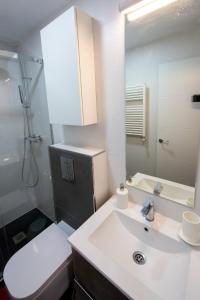 a bathroom with a sink and a toilet and a mirror at Wind Rose 10 - Moderno duplex a estrenar in San Lorenzo de El Escorial