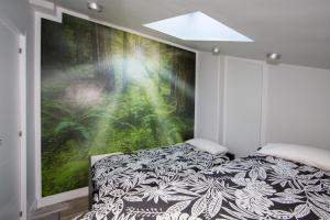 a bedroom with a large painting on the wall at Wind Rose 10 - Moderno duplex a estrenar in San Lorenzo de El Escorial