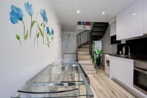 un comptoir en verre dans une cuisine avec des fleurs bleues sur le mur dans l'établissement Wind Rose 10 - Moderno duplex a estrenar, à San Lorenzo de El Escorial