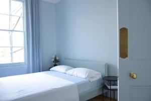 sypialnia z łóżkiem z białą pościelą i oknem w obiekcie Lovely 1-bedroom flat in Chelsea w Londynie
