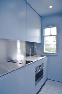 a white kitchen with a sink and a window at Lovely 1-bedroom flat in Chelsea in London