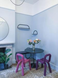 a table with two purple chairs and a vase of flowers at Lovely 1-bedroom flat in Chelsea in London
