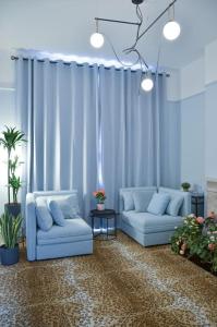 two blue couches sitting in a room with curtains at Lovely 1-bedroom flat in Chelsea in London