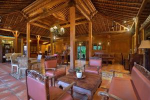 a living room with a wooden table and chairs at Mahe Garden Inn and Villas by Kamara in Kuta