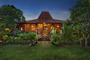 a house with a pathway leading to the front door at Mahe Garden Kuta Villas in Kuta +32 photos