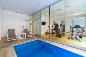 a gym with a swimming pool and exercise equipment at Boutique Suites Palermo in Buenos Aires