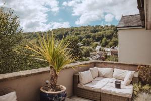 un sofá sentado en un balcón con una planta en The Grange Matlock Bath, en Matlock