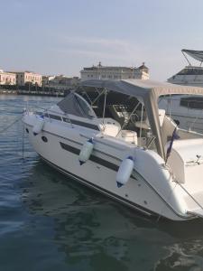 a white boat is docked in the water at albatiara rent boat in Siracusa