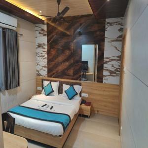 a bedroom with a bed and a mirror at Hotel Prasad NX in Mumbai
