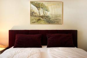 un cuadro sobre una cama en un dormitorio en Haus & Villa Strandburg by Rujana, en Binz