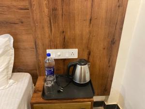 a tea kettle and a water bottle on a table next to a bed at The Offbeat Lounge in Udaipur