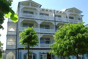 ビンツにあるHaus & Villa Strandburg by Rujanaのバルコニーと木々のある白い大きな建物