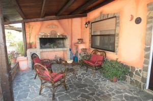 een patio met stoelen, een tafel en een open haard bij Casa Sa Carrubedda in SantʼAnna Arresi