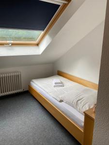 a small bedroom with a bed and a window at Silvio-Gesell-Tagungsstätte in Wuppertal