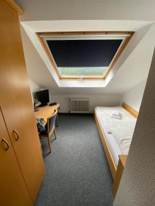 Cette chambre comprend un lit, un bureau et une télévision. dans l'établissement Silvio-Gesell-Tagungsstätte, à Wuppertal