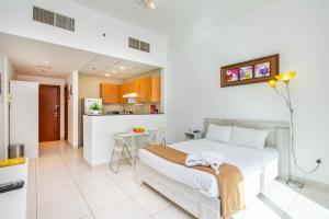 1 dormitorio con 1 cama y cocina en Bespoke Holiday Homes - Studio Apartment with Marina View en Dubái