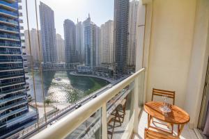 a balcony with a view of a river and buildings at Bespoke Holiday Homes - Studio Apartment with Marina View in Dubai