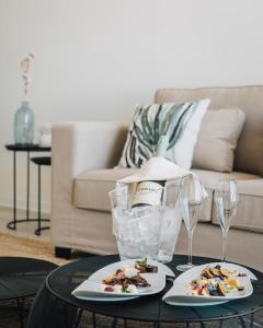 a table with two plates of food and wine glasses at Porto Covo Praia Hotel & SPA in Porto Covo