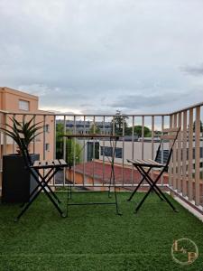 un par de sillas y una mesa en el balcón en La Comoé - 5 min centre Pau - 1 chambre - Parking, en Billère