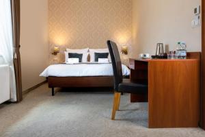 a bedroom with a bed and a desk with a chair at Aparthotel Globus Kraków in Krakow