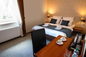 a hotel room with a bed with a desk and a table at Aparthotel Globus Kraków in Kraków