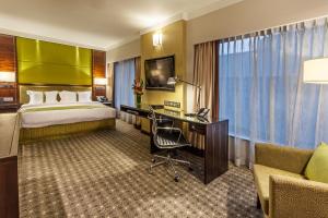 una camera d'albergo con letto e scrivania di Holiday Inn Singapore Orchard City Centre, an IHG Hotel a Singapore