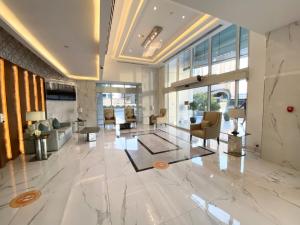 Dubai Marina - 5 bedroom, resort feel, great Amenities في دبي: لوبي مبنى فيه كراسي وطاولات