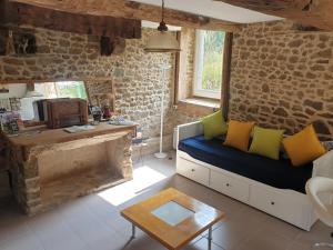 a living room with a couch and a table at Gîte Le Valet, T2 classé 3 étoiles, entre Rennes et Saint-Malo in La Chapelle-aux-Filzméens