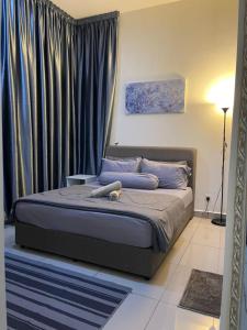 1 dormitorio con 1 cama grande y cortinas azules en IOI Conezion Iman's Home with Pool View Unit en Putrajaya