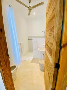 a bathroom with a toilet and a sink at Nyumba Nyekundu in Watamu